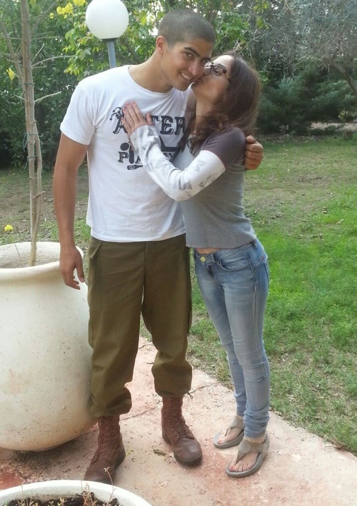 Ziv Hagbi in a garden as a woman affectionately kisses his cheek