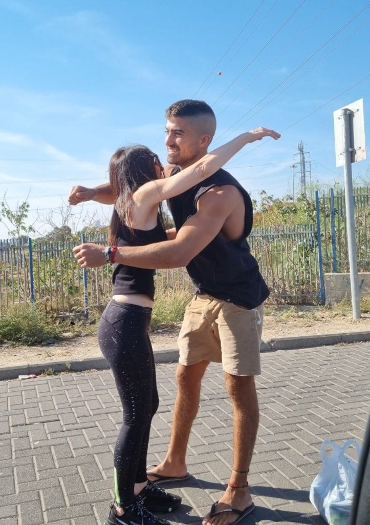 Ziv Hagbi sharing a joyful hug with a young woman on a sunny day