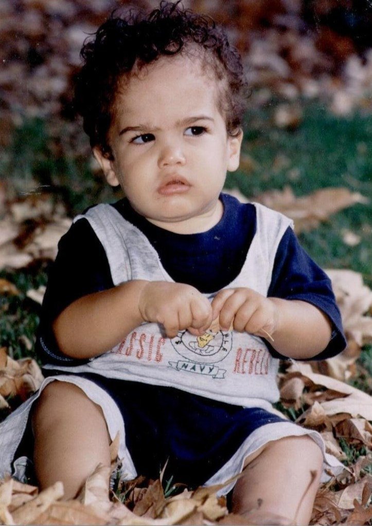Ziv Hagbi as a toddler sitting among autumn leaves, looking thoughtfully to the side