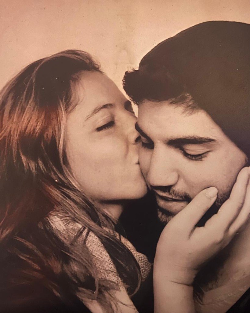 Noam Shay and Danielle Waldman. Danielle kisses Noam on the cheek as he rests his face in his hand.