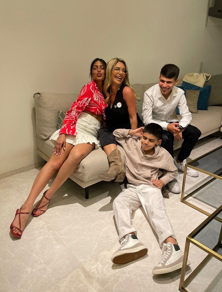 Kim Dukarker with family gathered together on the sofa, laughing and smiling