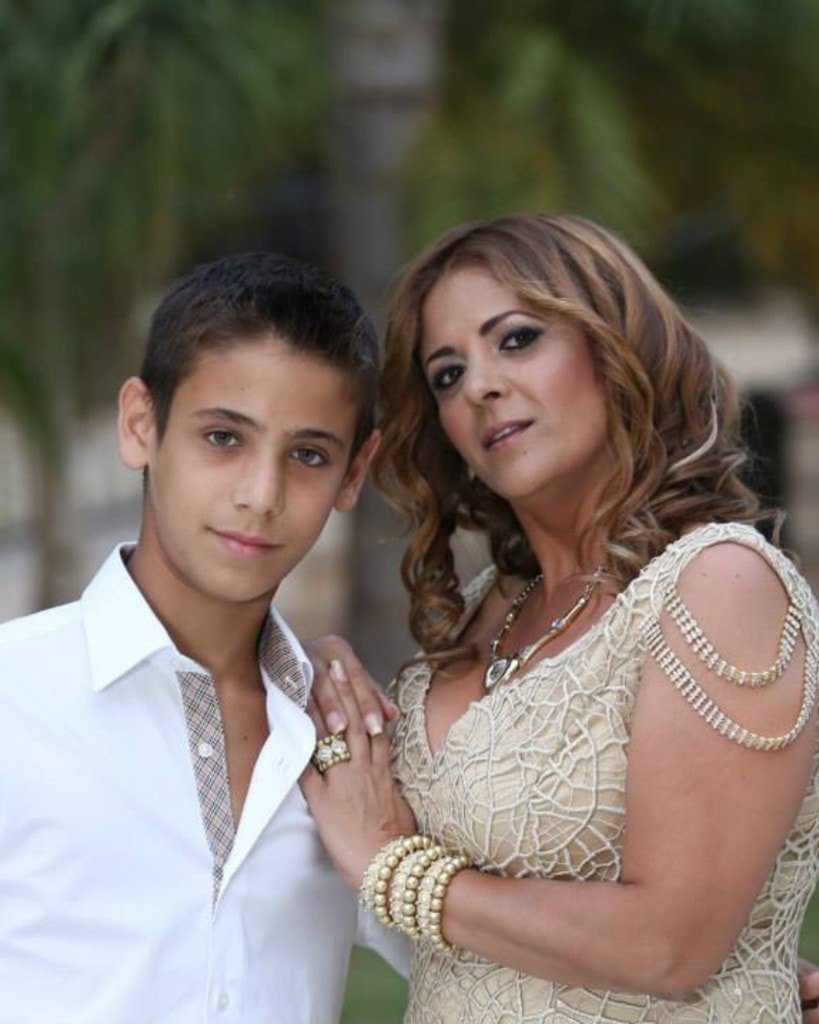 A young Ron Shemer in a white shirt standing beside a woman in a champagne-coloured dress