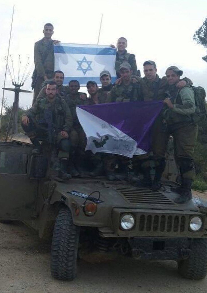Shaked Dahan with fellow soldiers on a military vehicle