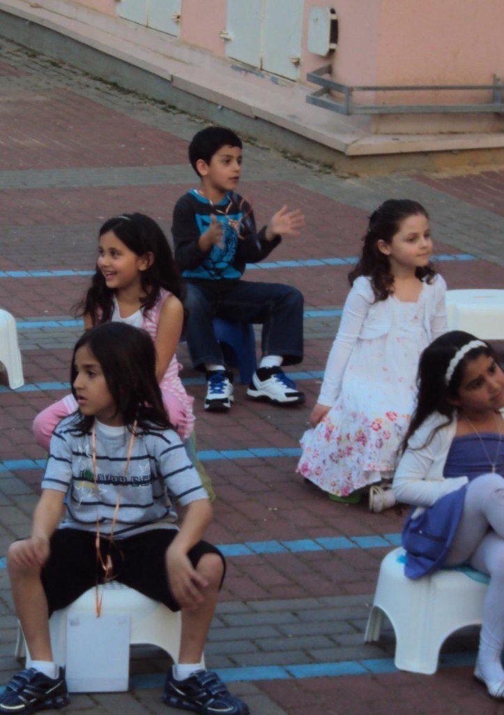 Shaked Dahan as a child sitting with classmates outdoors