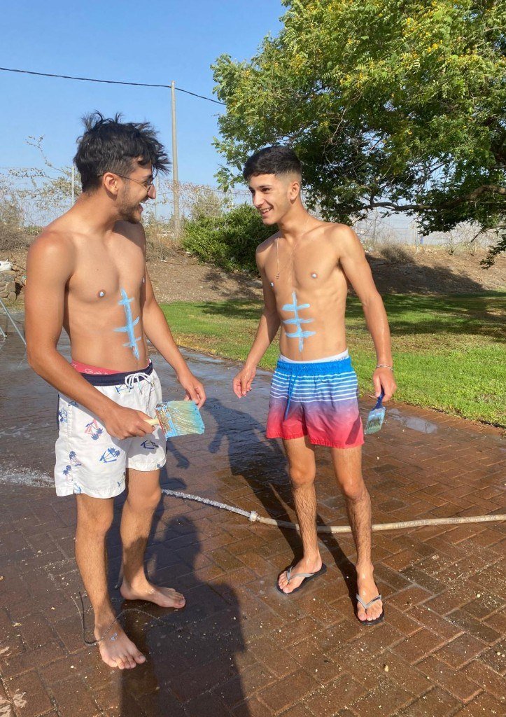 Shaked Dahan with a friend, smiling outdoors in summer